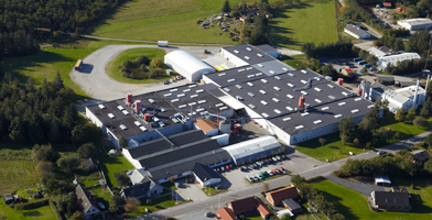 Vue aérienne du siège de l'entreprise, mettant en avant un vaste complexe moderne entouré de verdure.